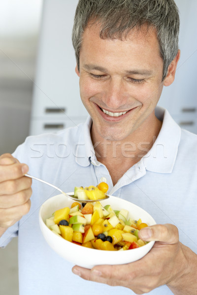 Középkorú férfi eszik friss gyümölcs saláta gyümölcs portré Stock fotó © monkey_business