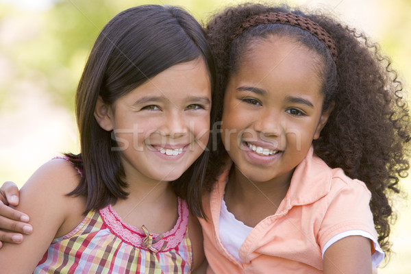 Kettő fiatal lány barátok ül kint mosolyog Stock fotó © monkey_business