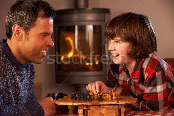 Father And Son Playing Chess By Cosy Log Fire Stock photo © monkey_business