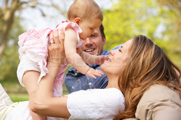 Parents With Baby Girl Sitting In Field Of Summer Flowers Stock photo © monkey_business