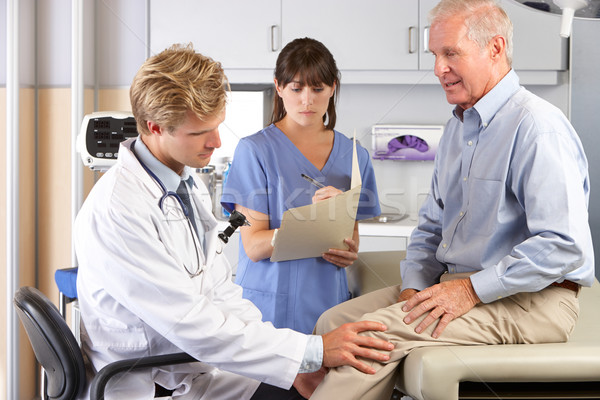 Arts onderzoeken mannelijke patiënt knie pijn Stockfoto © monkey_business