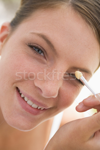 Woman with eyeshadow applicator smiling Stock photo © monkey_business