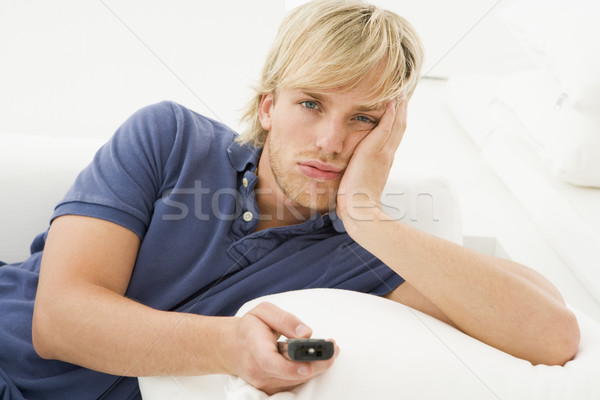Man in living room holding remote control Stock photo © monkey_business