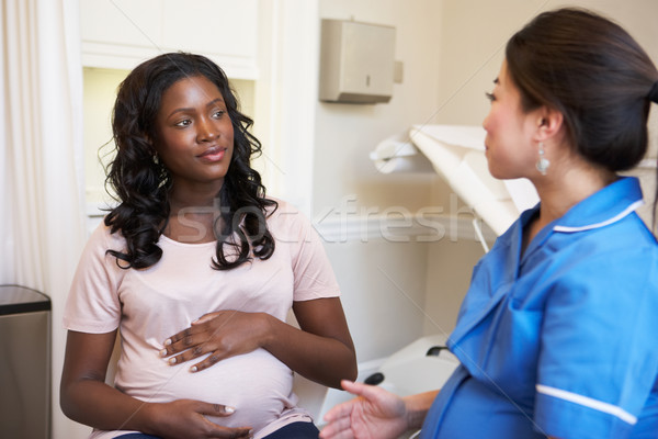 Femeie gravida Reuniunea asistentă clinică femei spital Imagine de stoc © monkey_business