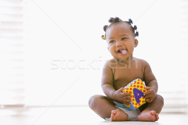 Baby sitting indoors with block smiling Stock photo © monkey_business