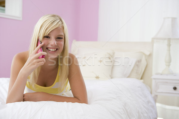 Tinilány ágy mobiltelefon boldog tini kommunikáció Stock fotó © monkey_business