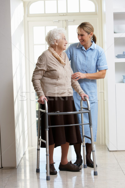 Stock photo: Carer Helping Elderly Senior Woman Using Walking Frame