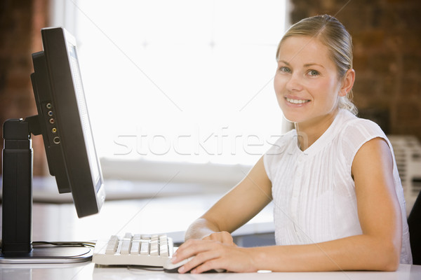 Businesswoman sitting in office with computer smiling Stock photo © monkey_business