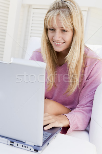 женщину патио используя ноутбук улыбающаяся женщина улыбаясь компьютер Сток-фото © monkey_business