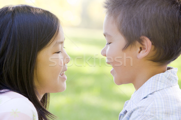 Brother and sister outdoors staring at each other and smiling Stock photo © monkey_business