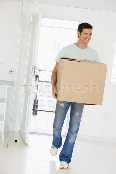 Man with box moving into new home smiling Stock photo © monkey_business