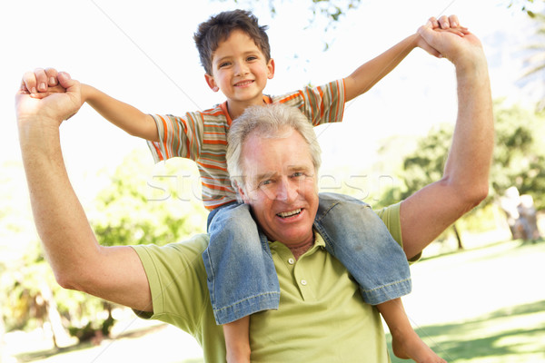 Grandfather Giving Grandson Ride On Back In Park Stock photo © monkey_business