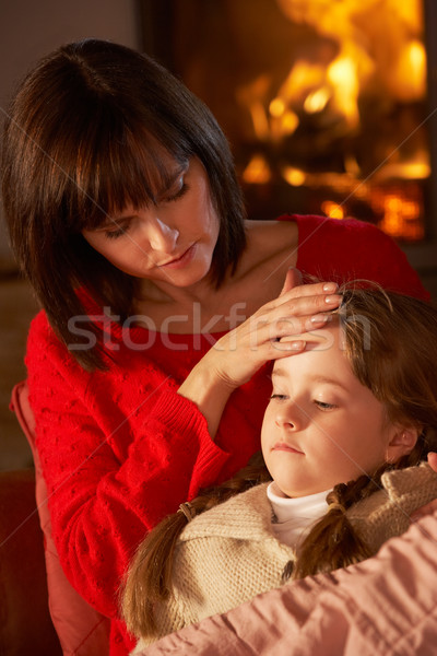 Mother Comforting Sick Daughter On Sofa By Cosy Log Fire Stock photo © monkey_business