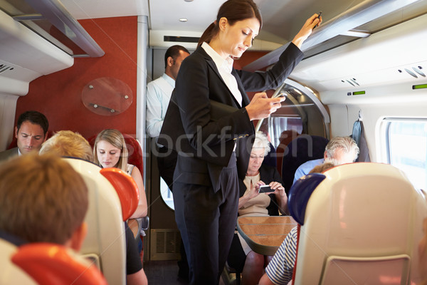 Businesswoman Using Mobile Phone On Busy Commuter Train Stock photo © monkey_business