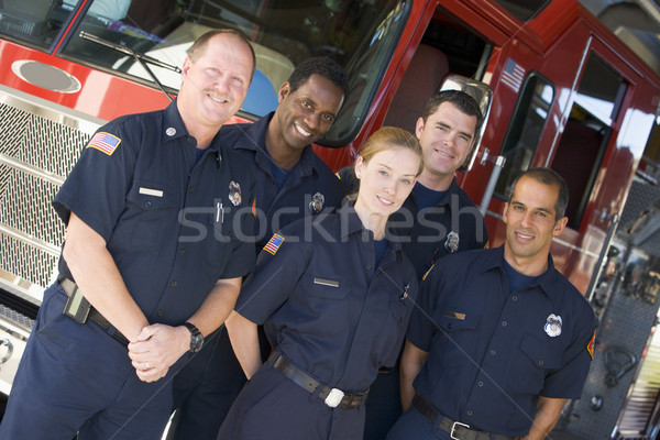 Stock photo: Portrait of firefighters standing by a fire engine