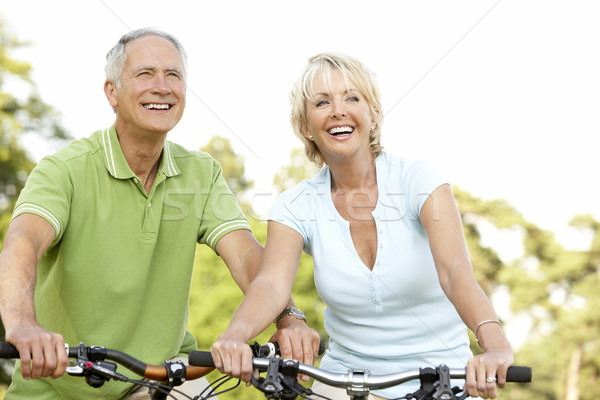 Stock photo: Mature couple riding bikes
