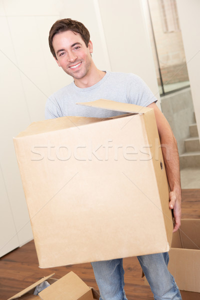 Young man on moving day holding and carrying cardboard box Stock photo © monkey_business
