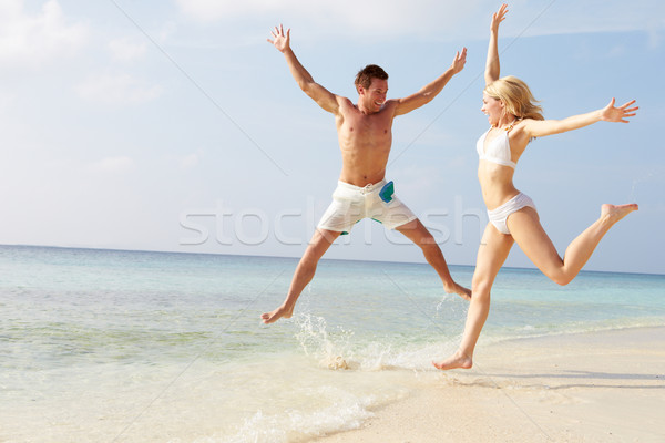 Couple Jumping In The Air On Tropical Beach Stock photo © monkey_business