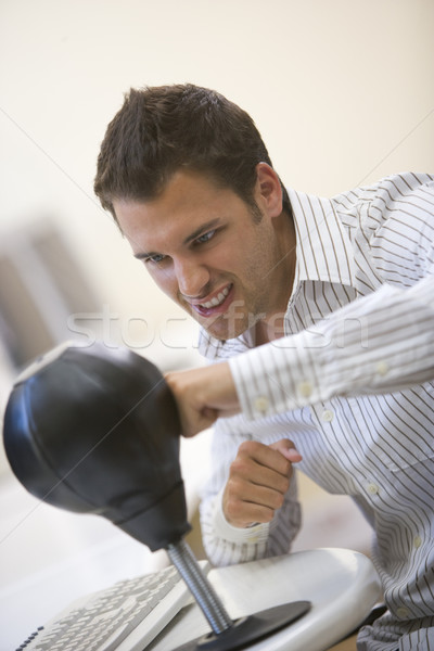 Man sitting in computer room using small punching bag for stress Stock photo © monkey_business
