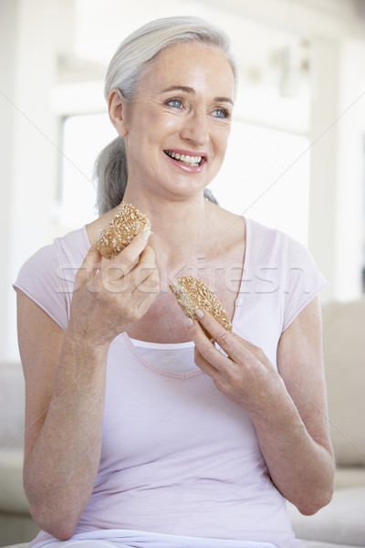 Stock photo: Senior Woman Eating Brown Bread Roll