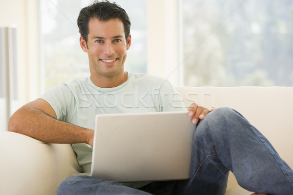 Człowiek salon za pomocą laptopa uśmiechnięty komputera domu Zdjęcia stock © monkey_business