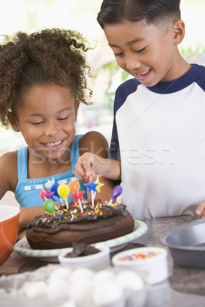 Two children in kitchen with birthday cake smiling Stock photo © monkey_business