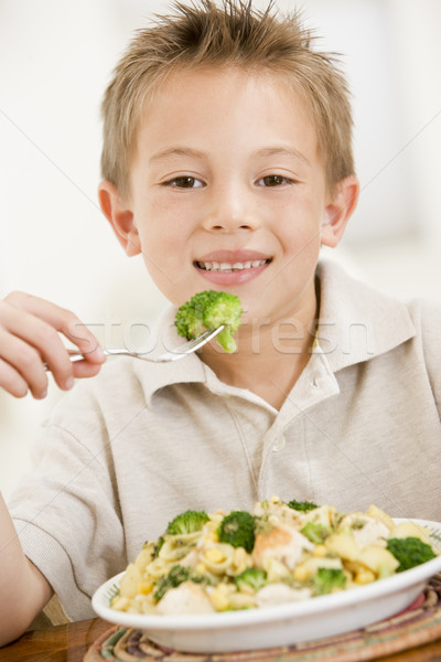 Young boy indoors eating pasta with brocolli smiling Stock photo © monkey_business