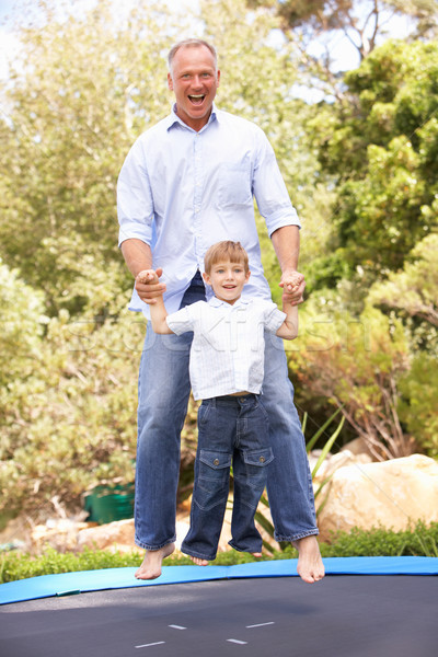 Figlio di padre jumping trampolino giardino ritratto padre Foto d'archivio © monkey_business