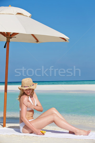 Woman Applying Sun Lotion On Beach Holiday Stock photo © monkey_business