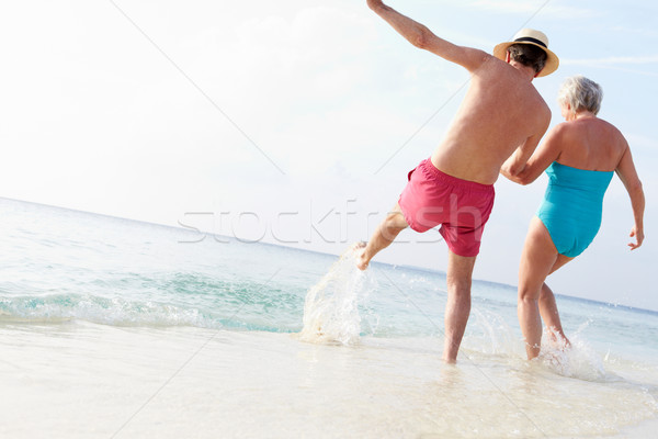 Senior Couple Splashing In Sea On Beach Holiday Stock photo © monkey_business