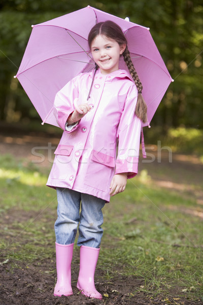 Young girl outdoors with umbrella smiling Stock photo © monkey_business