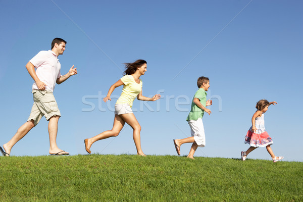 Stock photo: Young family, parents with children,  running through field