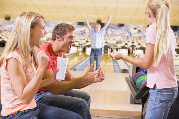 Family in bowling alley cheering and smiling Stock photo © monkey_business