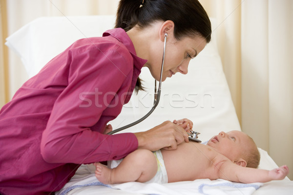 Doctor giving checkup with stethoscope to baby in exam room Stock photo © monkey_business