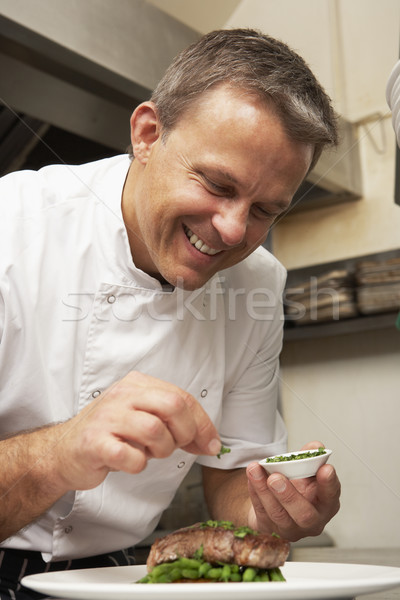 Chef Adding Seasoning To Dish In Restaurant Kitchen Stock photo © monkey_business