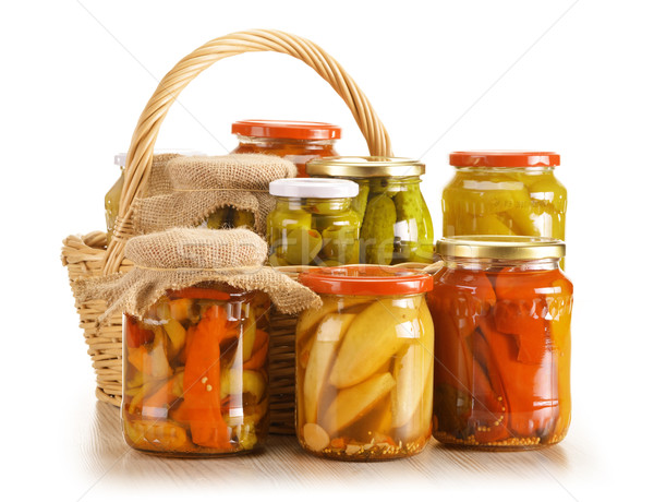 Composition with wicker basket and jars of pickled vegetables. Stock photo © monticelllo