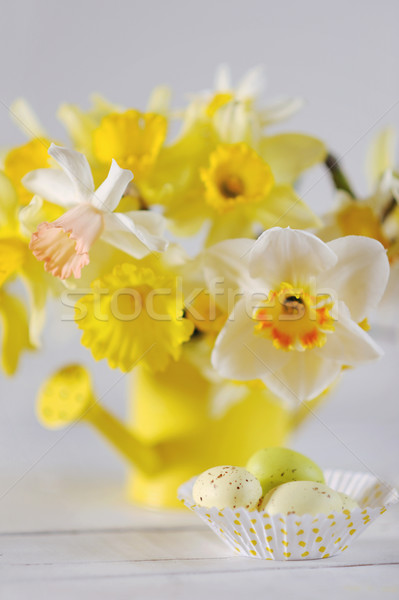 Springtime Daffodils In Full Bloom with colorful Easter eggs on the table Stock photo © Moravska