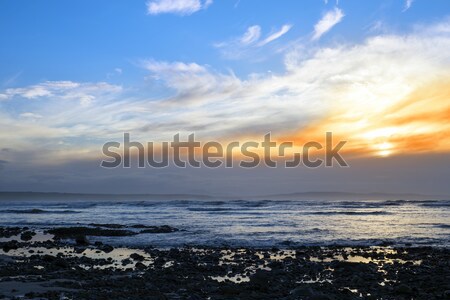 beautiful yellow sunset sky over rocky beach Stock photo © morrbyte