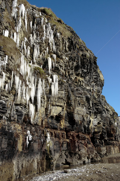 thawing cascade of icicles on a cliff face Stock photo © morrbyte