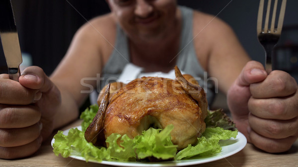 Homem gordo comer gorduroso frango assado faca Foto stock © motortion