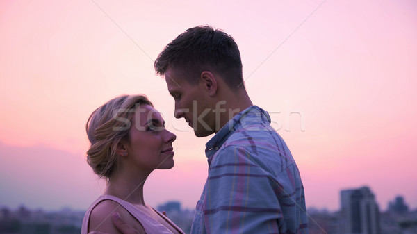 Tineri îndrăgostiţi ochi Reuniunea zori acoperiş Imagine de stoc © motortion