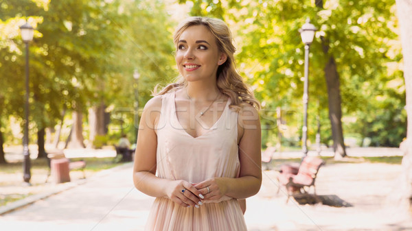 Beautiful lady with excitement waiting for her boyfriend, date in summer park Stock photo © motortion