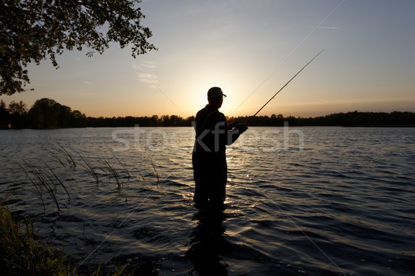 Fischer Silhouette stehen See Fisch Wasser Stock foto © mtmmarek