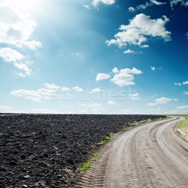 sun in dramatic sky over road near black field Stock photo © mycola