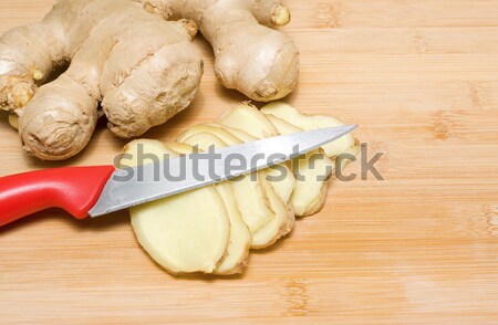 Stock photo: Ginger root on a bamboo chopping block