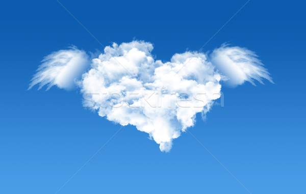 A heart shaped cloud formation against clear blue sky and flying with wings. Stock photo © myfh88