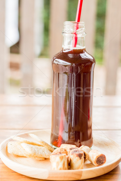 Bottle of black iced coffee with some snack Stock photo © nalinratphi