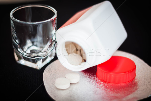 Open pill bottle with brown medicine spilling out   Stock photo © nalinratphi