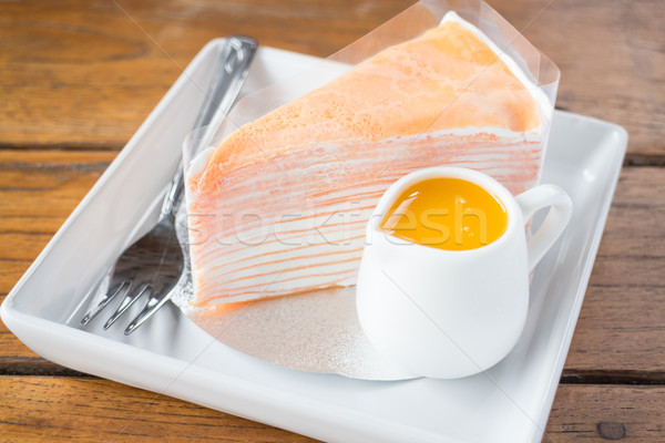 Homemade orange crepe cake serving on the plate Stock photo © nalinratphi