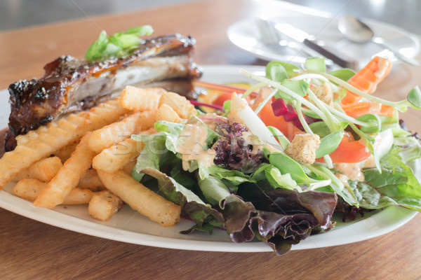 Delicious barbecued ribs with spicy sauce and organic salad Stock photo © nalinratphi